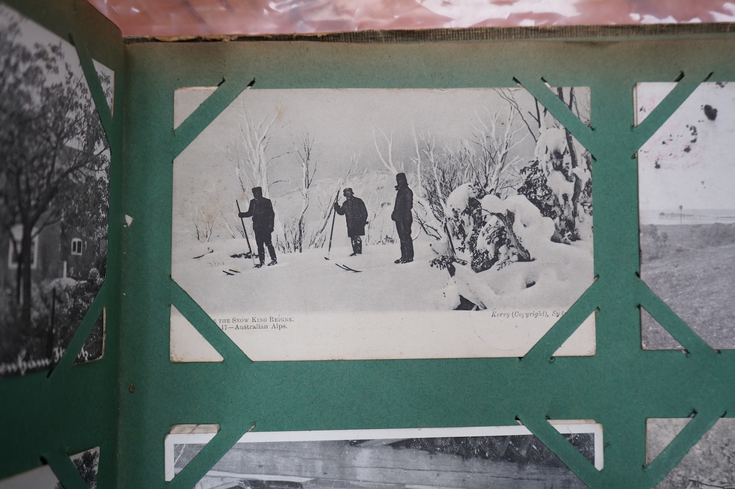 A postcard album with various postcards. Condition - damp damage